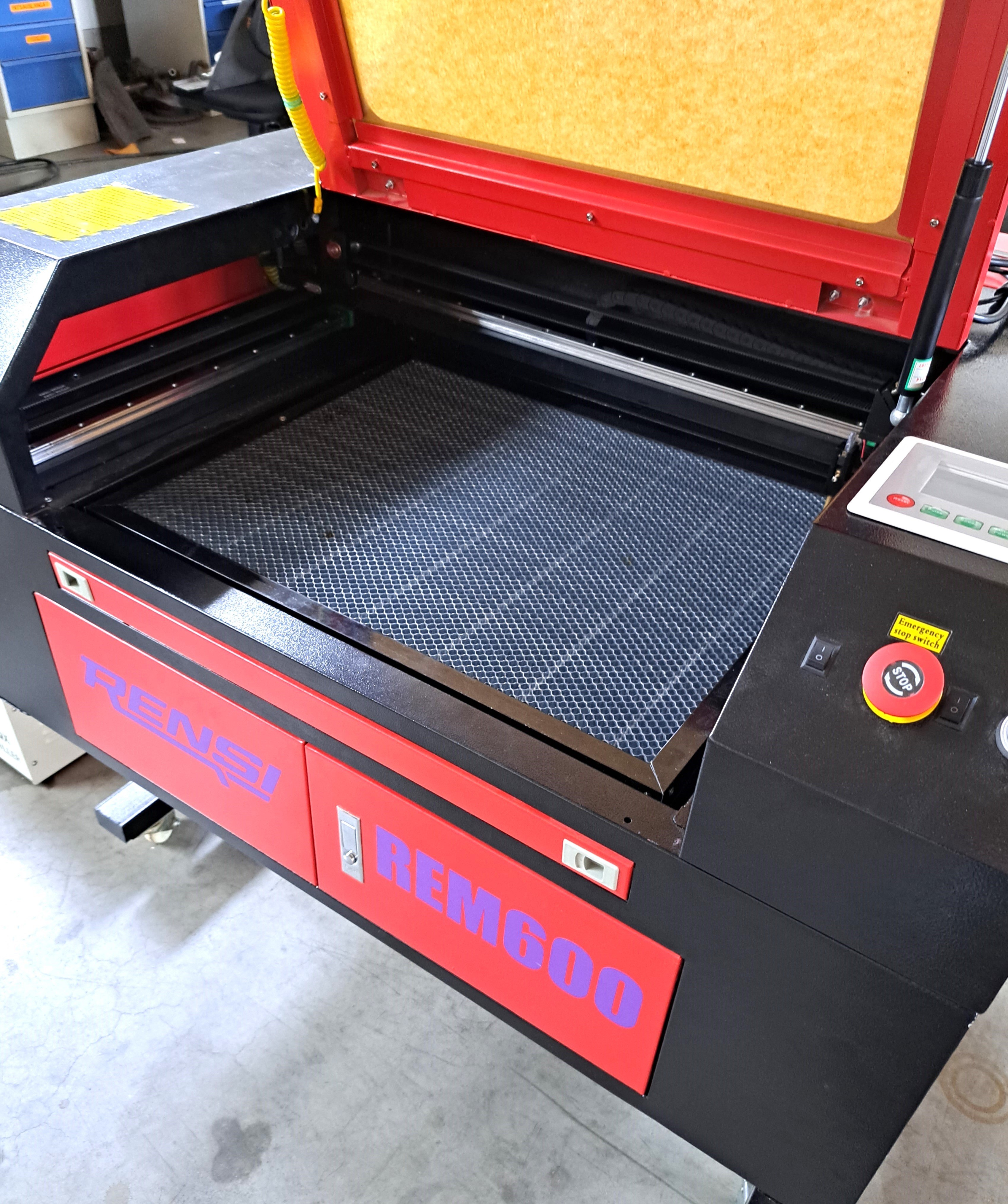 Laserkoneen hunajakenno pöytä ja sen vieressä oleva ilmapumppu.